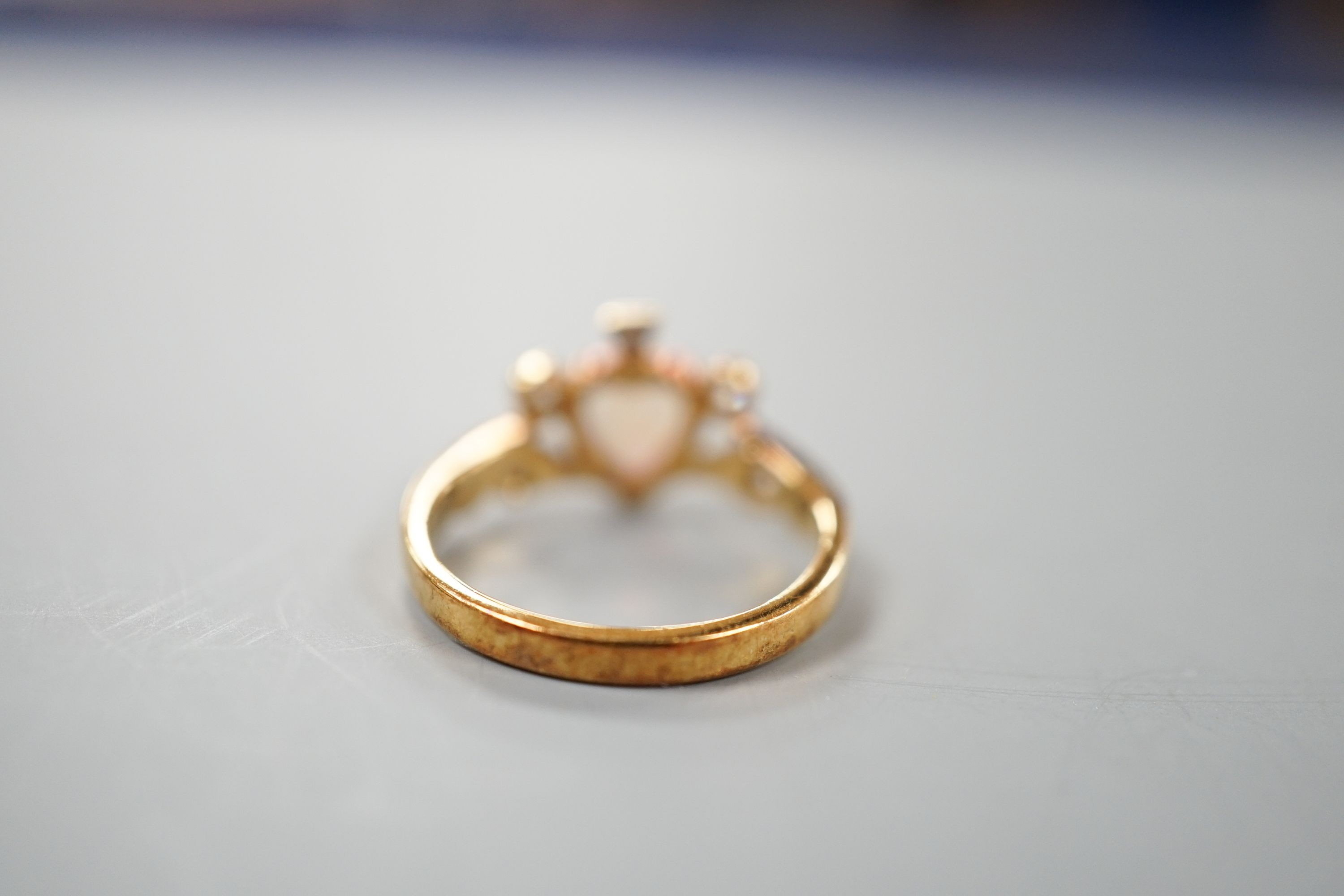 A late Victorian 18ct gold, heart shaped white opal and five stone diamond chip set dress ring, size I, gross weight 2.6 grams.